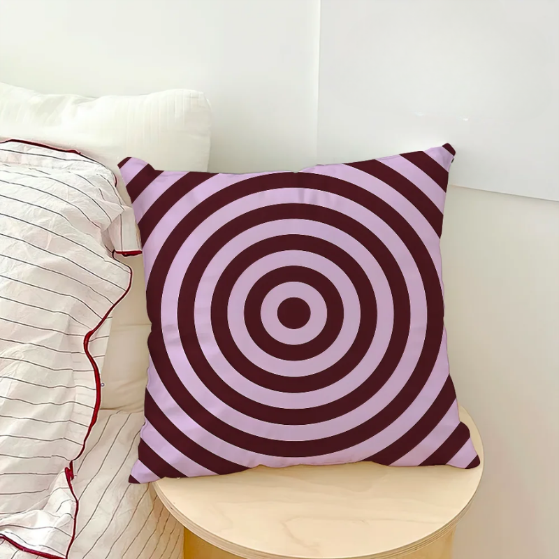 Decorative pillow with concentric circle pattern on a white couch.
