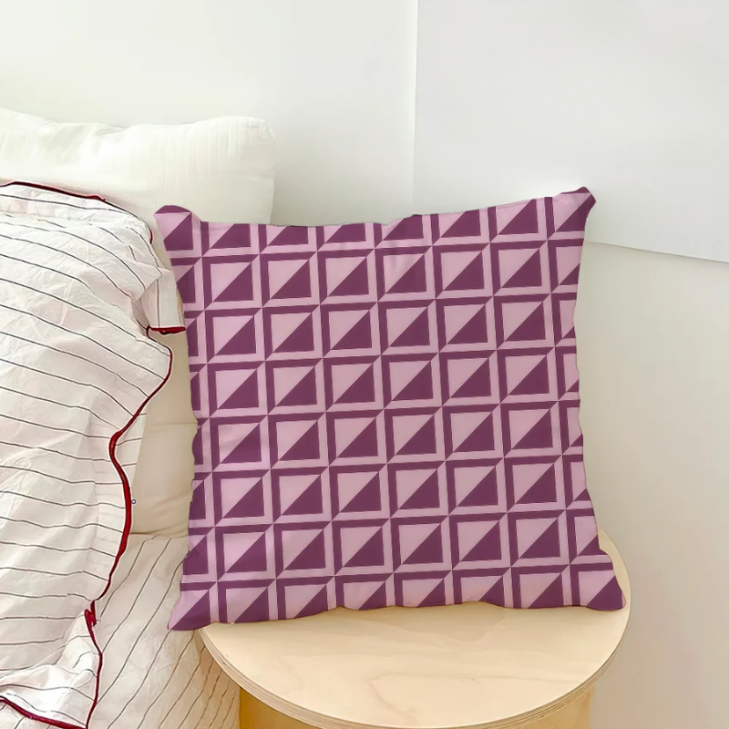 Purple geometric patterned pillow on a white couch with striped cushions.