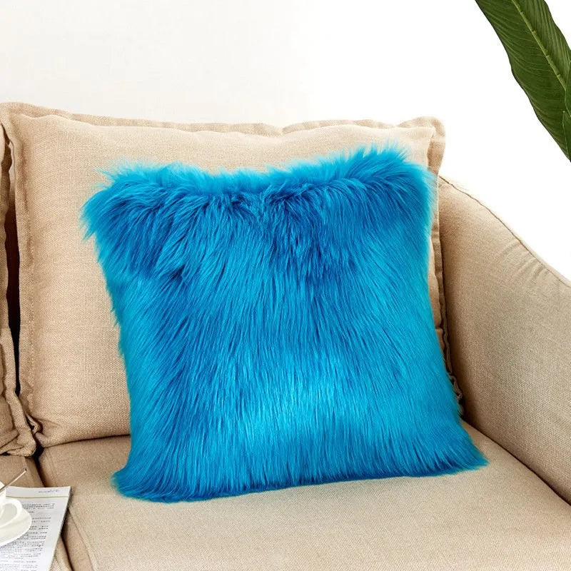 Blue fluffy pillow on a beige couch with a white background