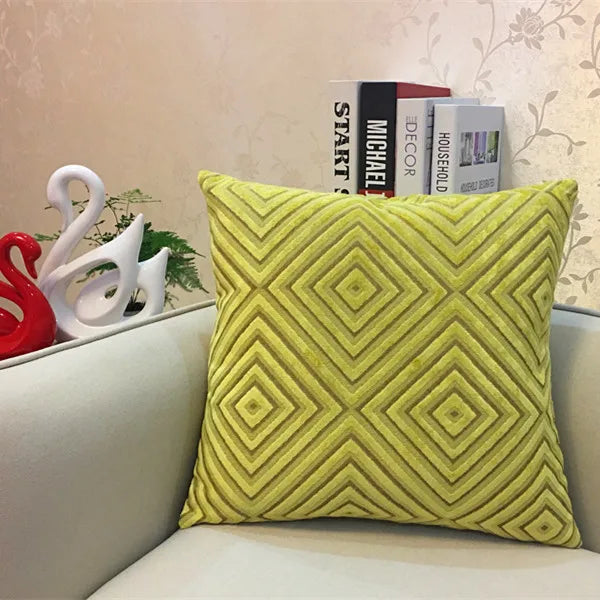 Yellow textured pillow on a sofa with decorative items in the background