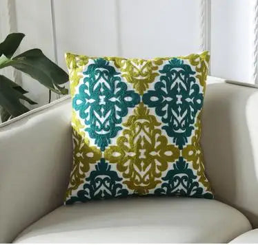 Decorative pillow with green and yellow pattern on a white couch