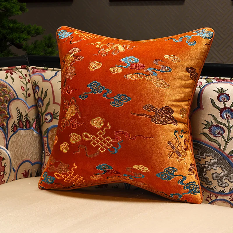 Decorative orange pillow with intricate patterns on a couch.
