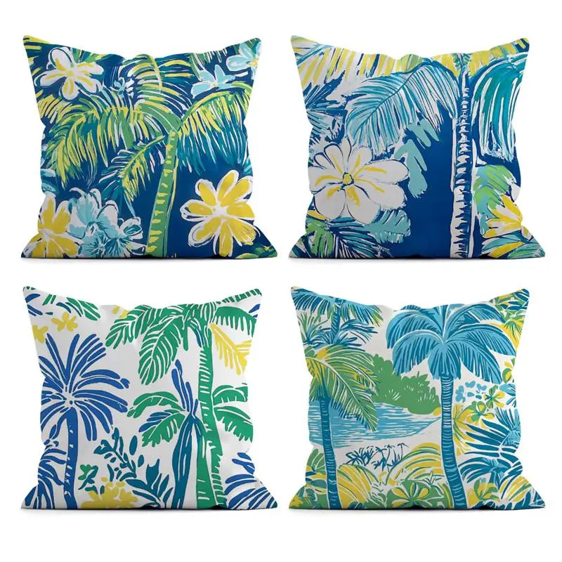 Four tropical-themed decorative pillows with palm trees and flowers on a white background.