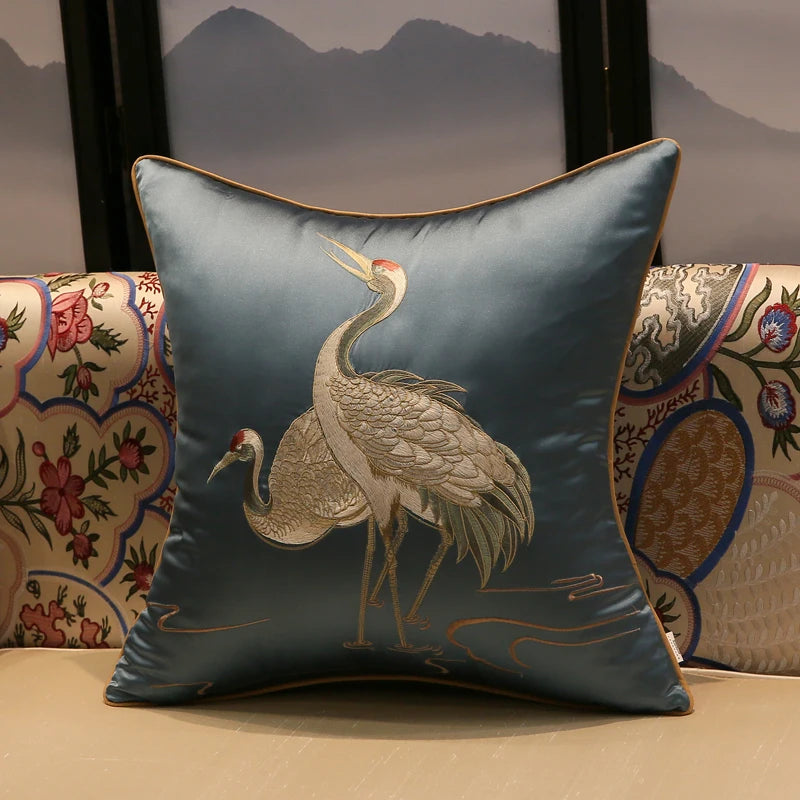 Decorative pillow with embroidered crane design on a patterned background