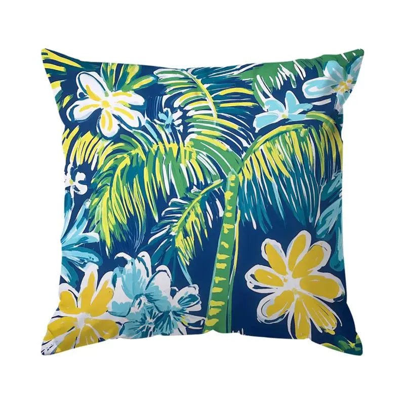 Tropical floral patterned pillow with palm leaves and flowers on a blue background