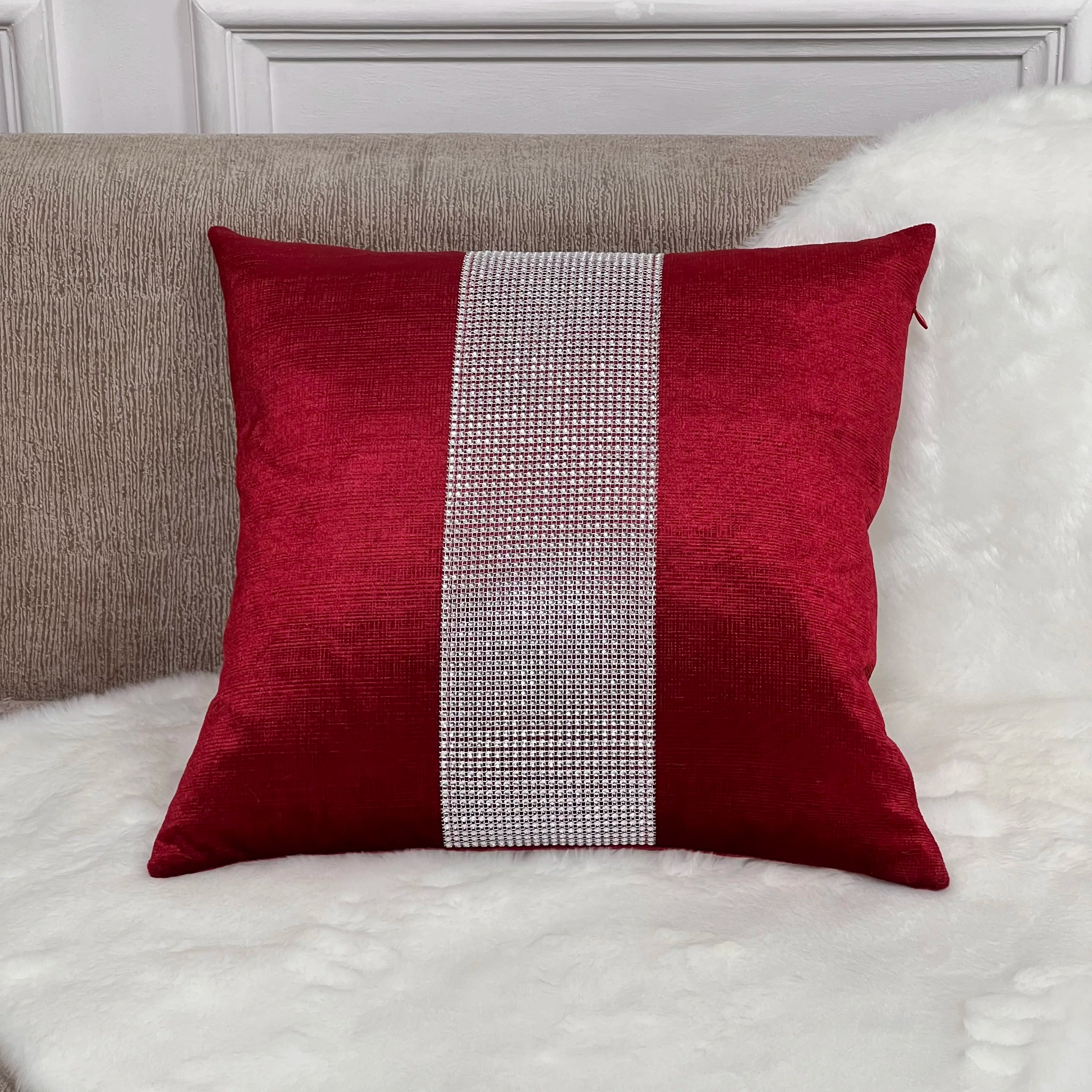 Red pillow with a silver stripe on a white sofa