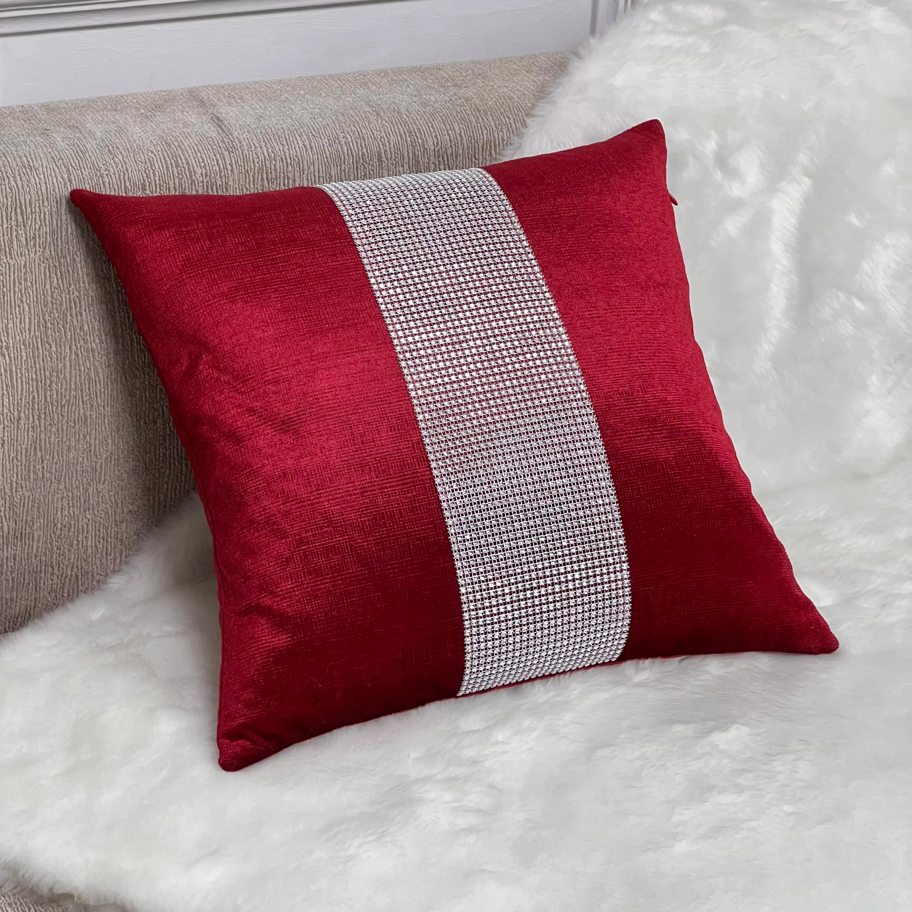Red pillow with a white stripe on a textured surface