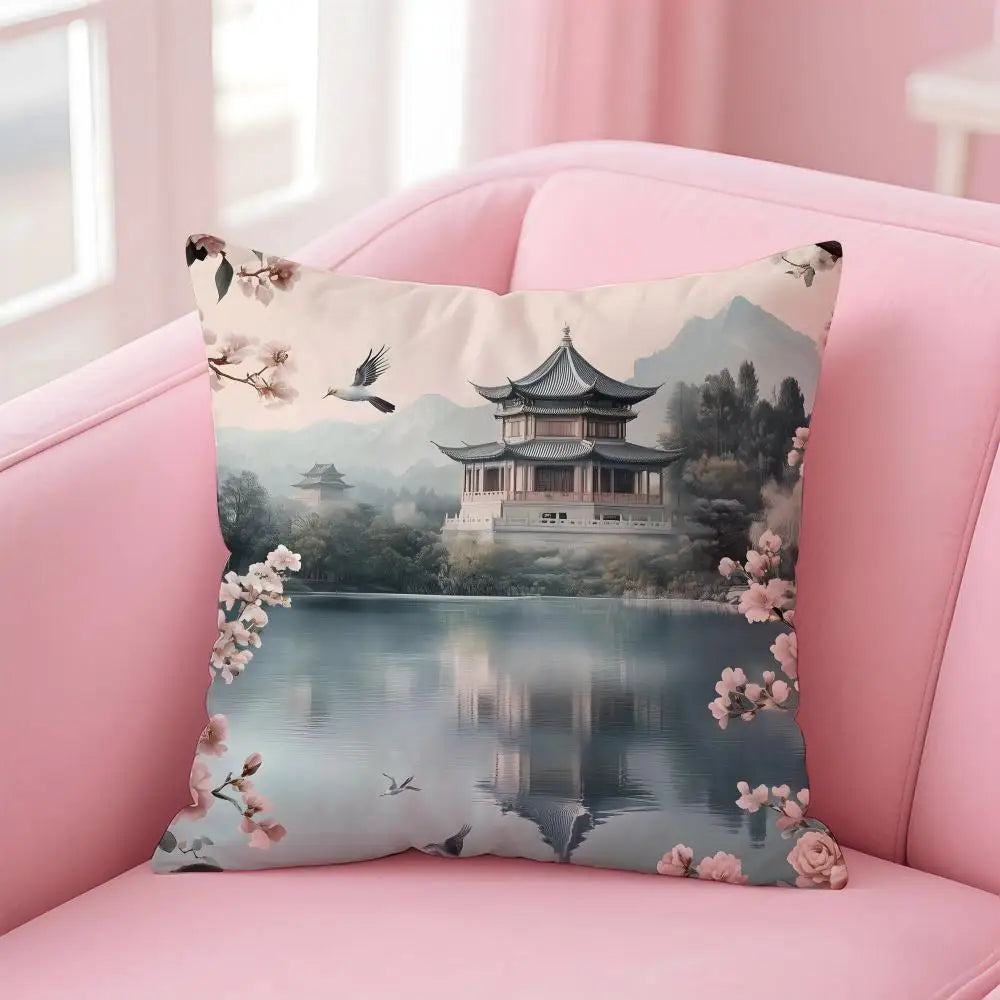 Decorative pillow with a scenic design of a pagoda and cherry blossoms on a pink couch.
