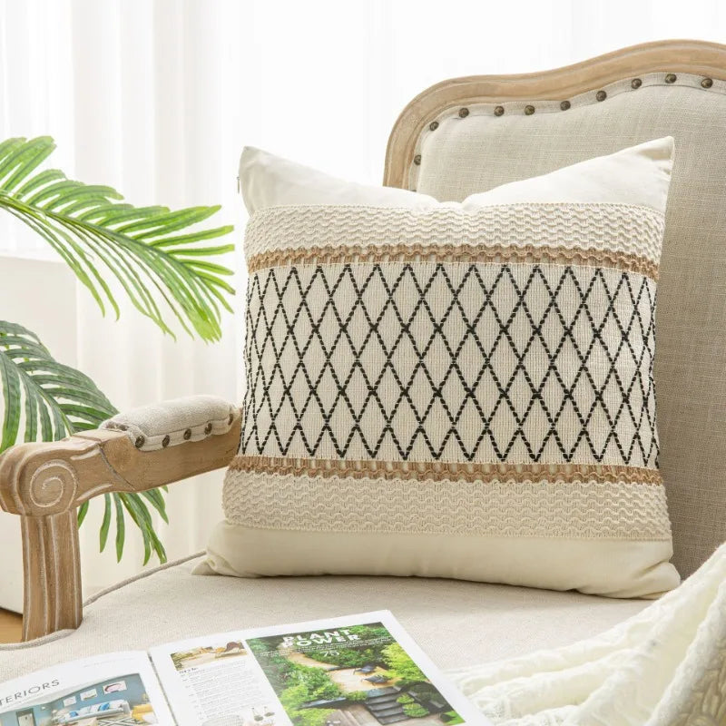Decorative pillow with geometric pattern on a sofa next to a plant
