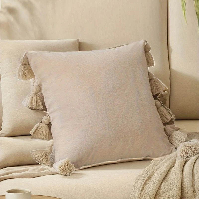 Beige pillow with tassels on a beige sofa