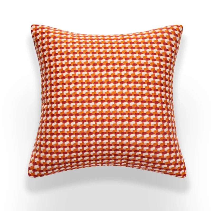 Orange and white checkered pillow on a white background
