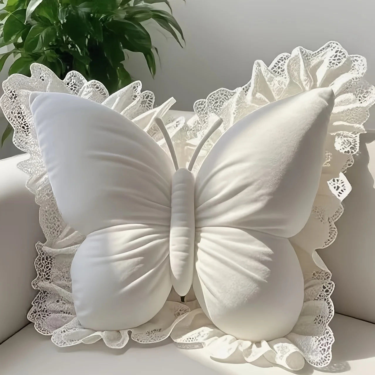 White butterfly-shaped pillow with lace details