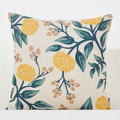 Decorative pillow with floral pattern featuring yellow flowers and green leaves on a beige background.