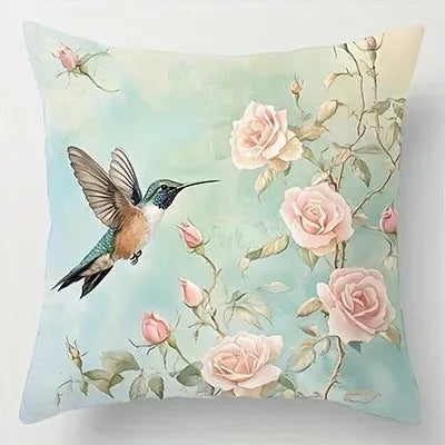 Decorative pillow with a hummingbird and pink roses on a light blue background