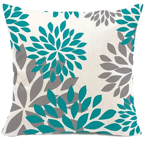 Decorative pillow with teal and gray floral pattern on a white background