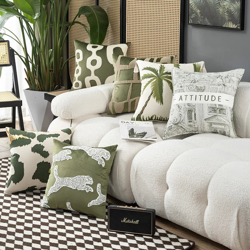 Decorative pillows on a white sofa with a plant and Marshall speaker in a room.