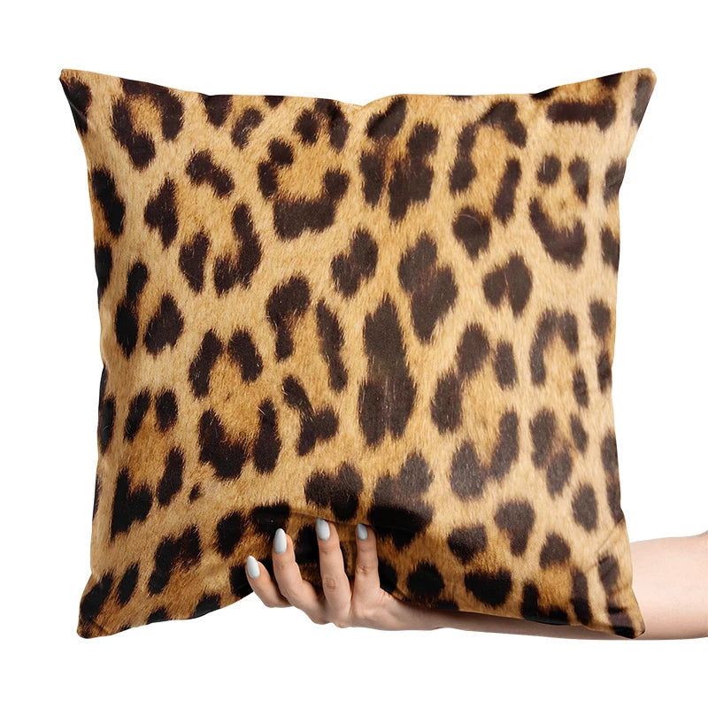 Leopard print pillow held by a hand on a white background