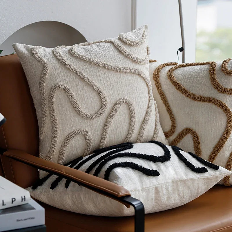 Decorative pillows with intricate patterns on a brown chair.