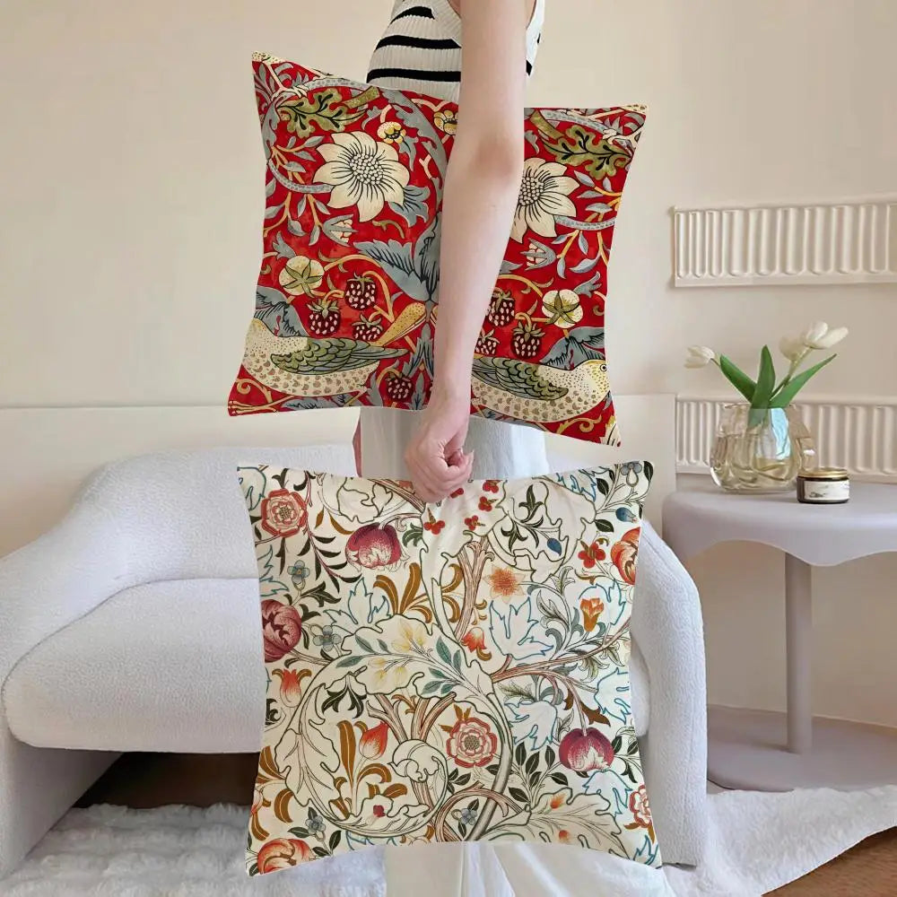 Person holding two floral-patterned pillows in a living room setting.