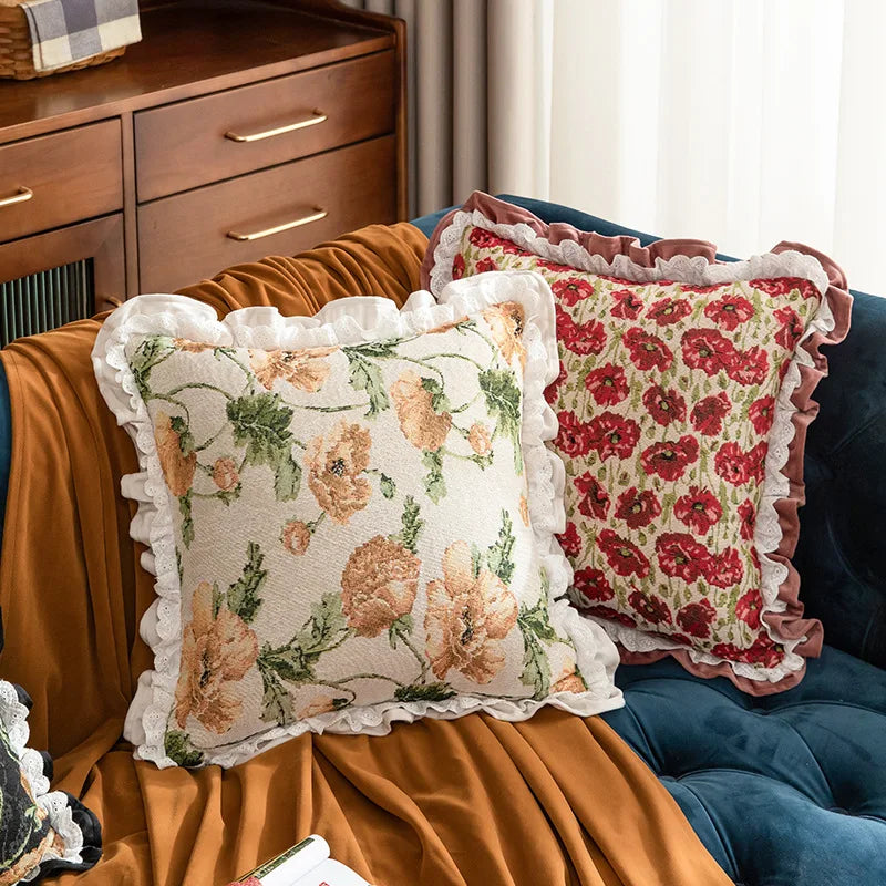 Floral patterned pillows on a couch with a wooden cabinet in the background