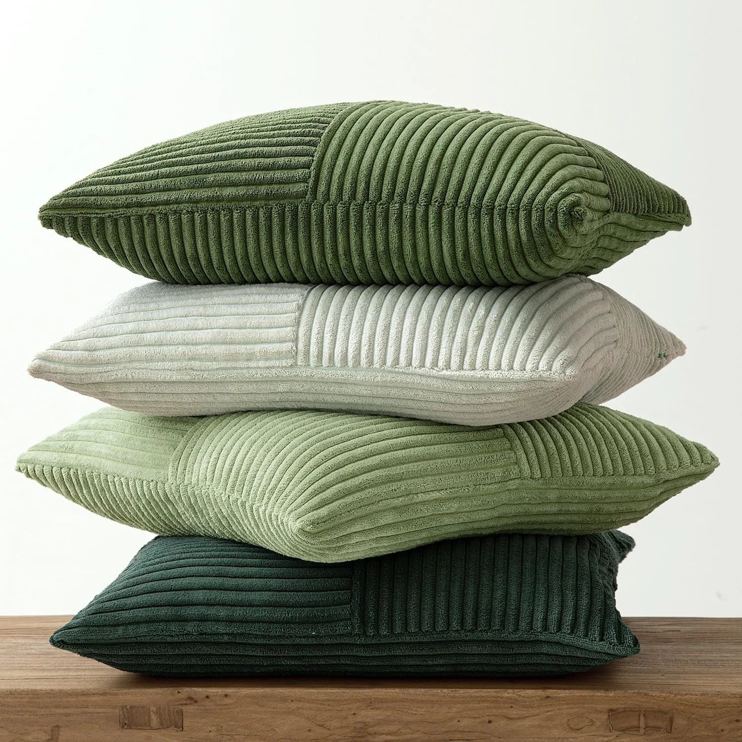 Stacked corduroy pillow covers in light and dark green shades