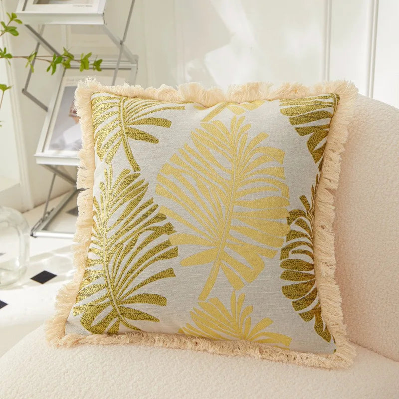 Decorative pillow with yellow leaf pattern on a white background
