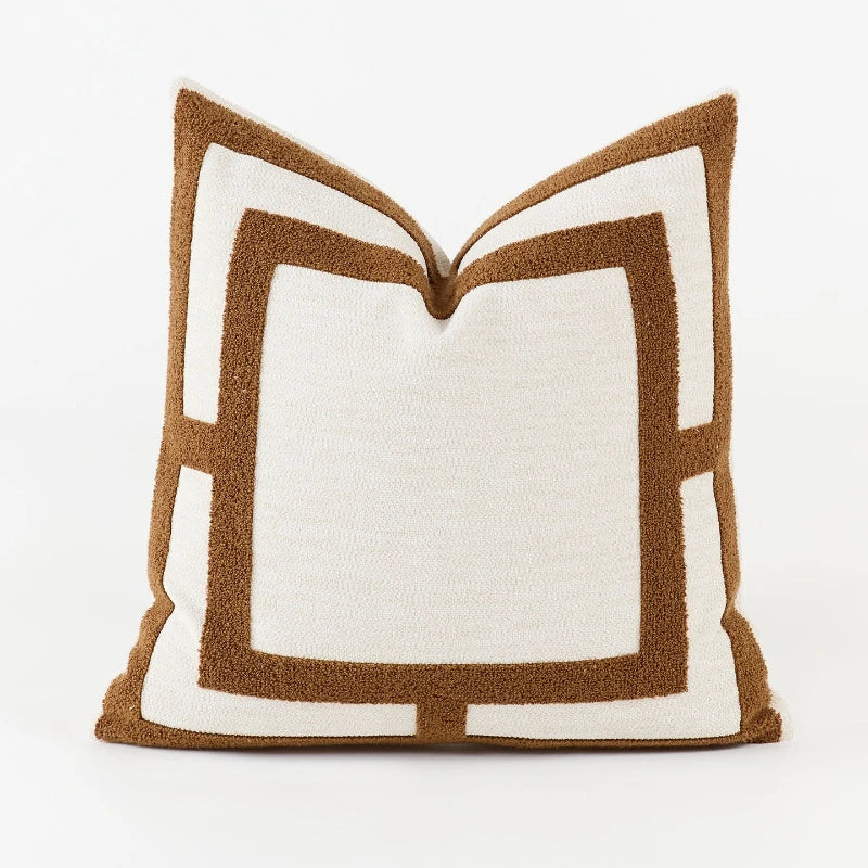 Decorative pillow with brown and white geometric pattern on a white background