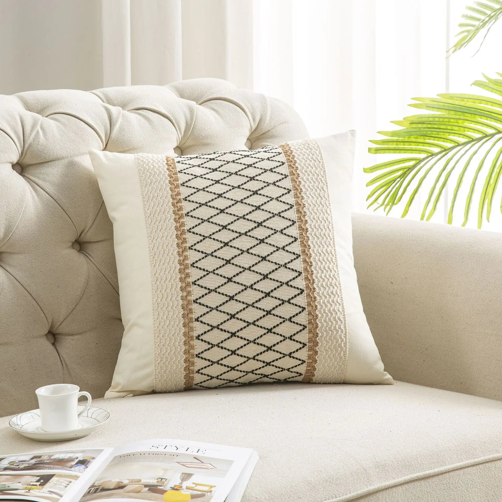 Decorative pillow on a beige sofa with a cup and magazine in the background
