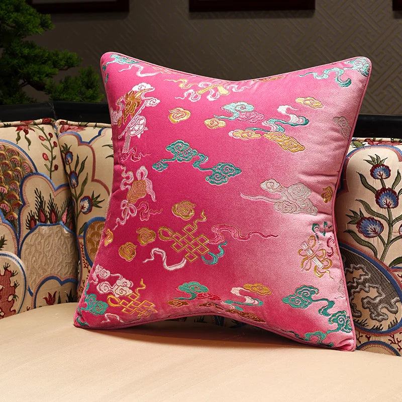 Decorative pink pillow with intricate patterns on a couch