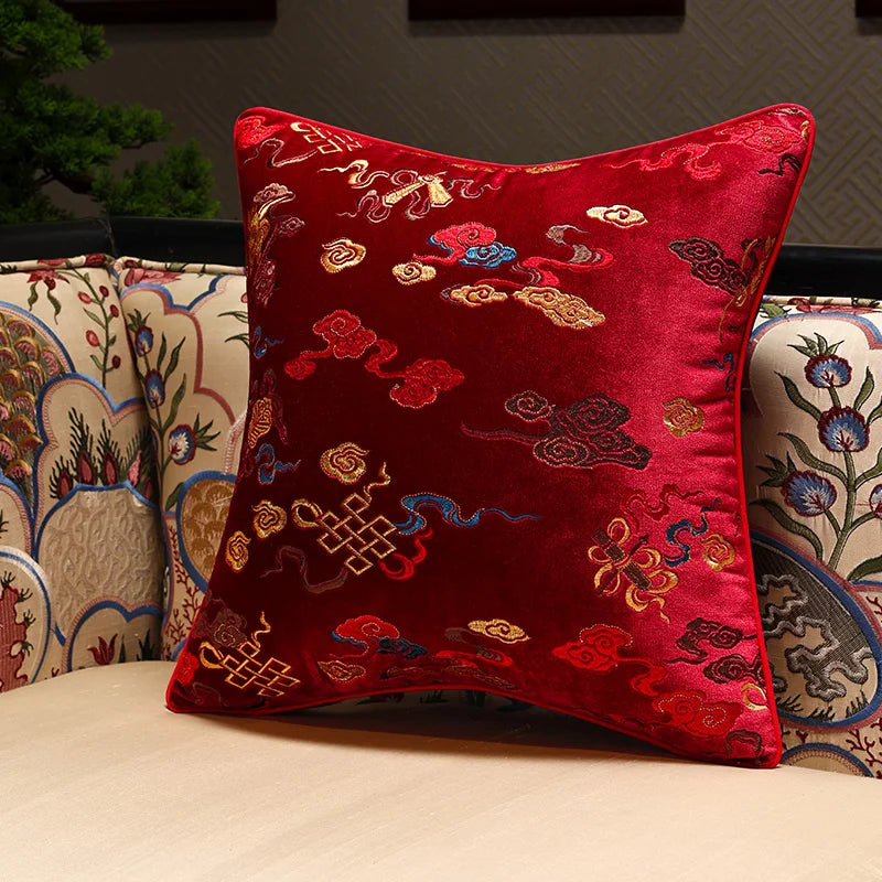 Red embroidered pillow on a patterned sofa