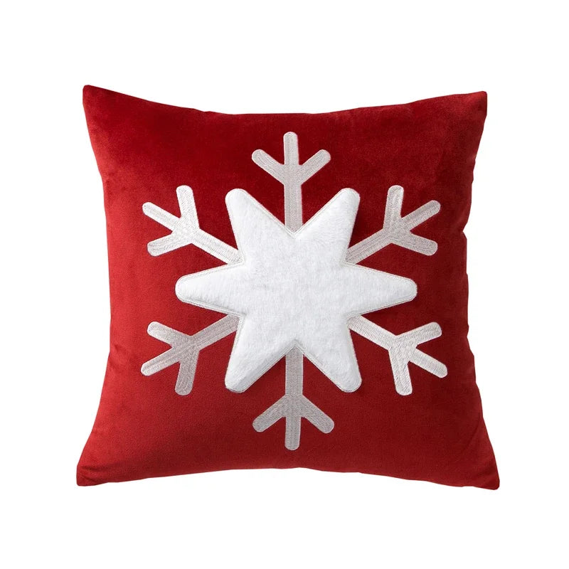 Red pillow with a white snowflake design on a white background
