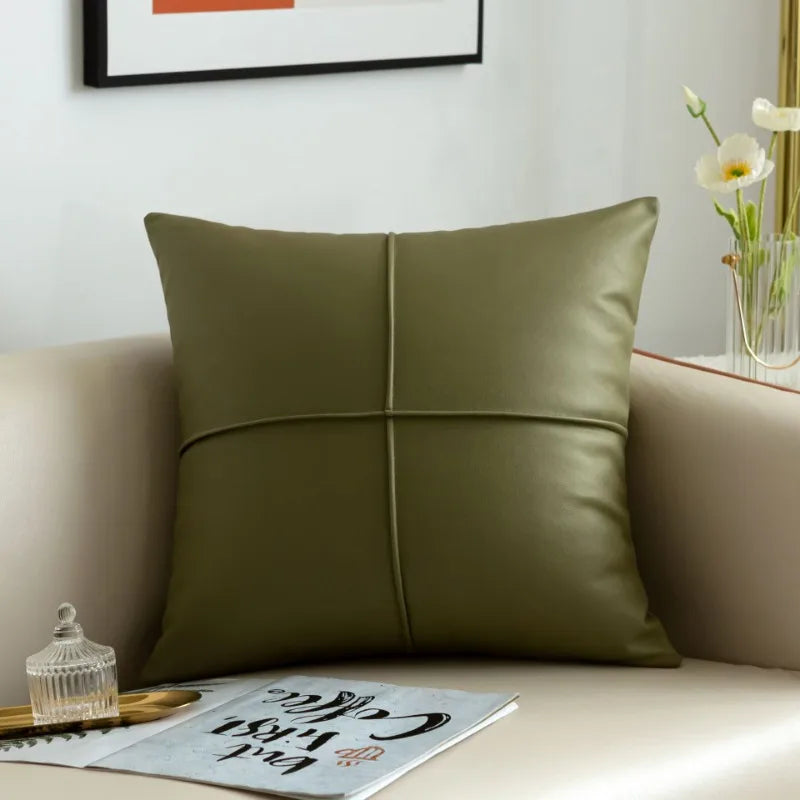 Green pillow on a beige sofa with a magazine and decorative items in the background.