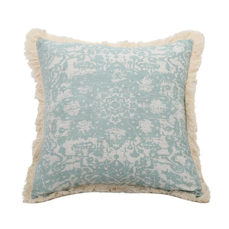 Decorative pillow with floral pattern and tassels on a white background