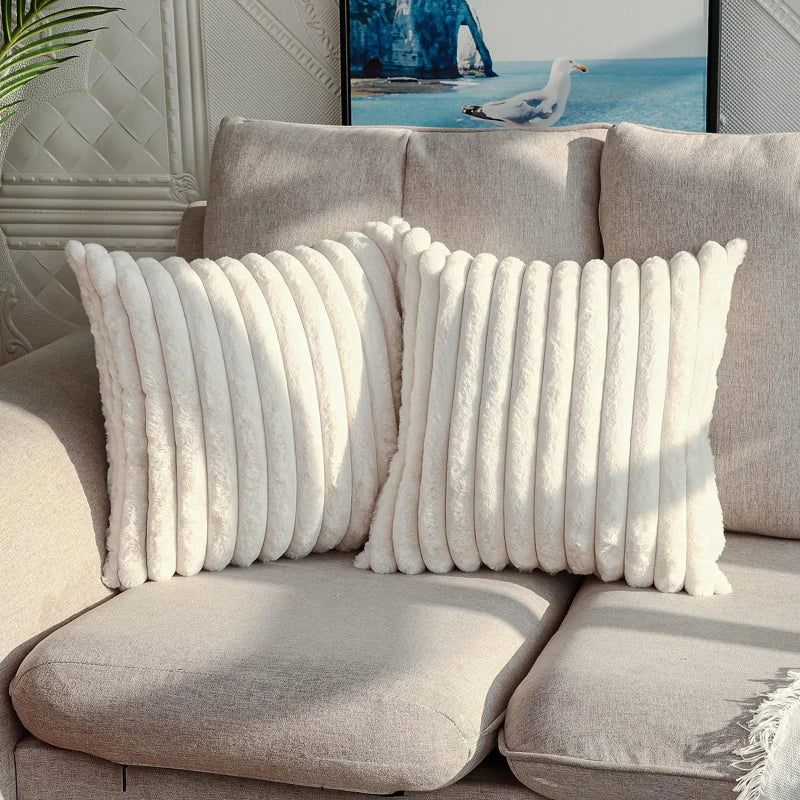 Gray sofa with white textured pillows in a living room setting.