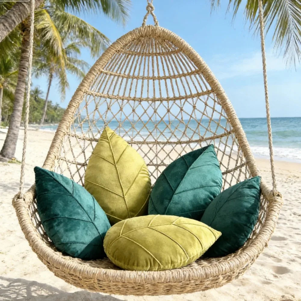 Woven hanging chair with green and yellow cushions on a beach