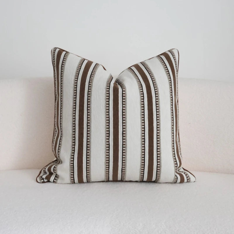 Striped pillow with brown and beige pattern on a white background