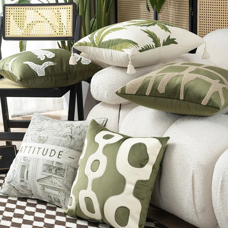 Decorative pillows with green and white patterns on a sofa
