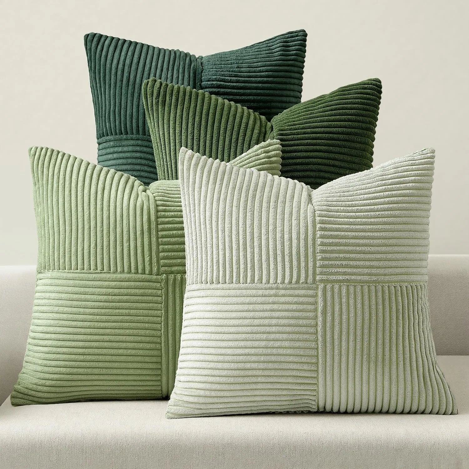 Green corduroy striped pillow covers in multiple shades on sofa