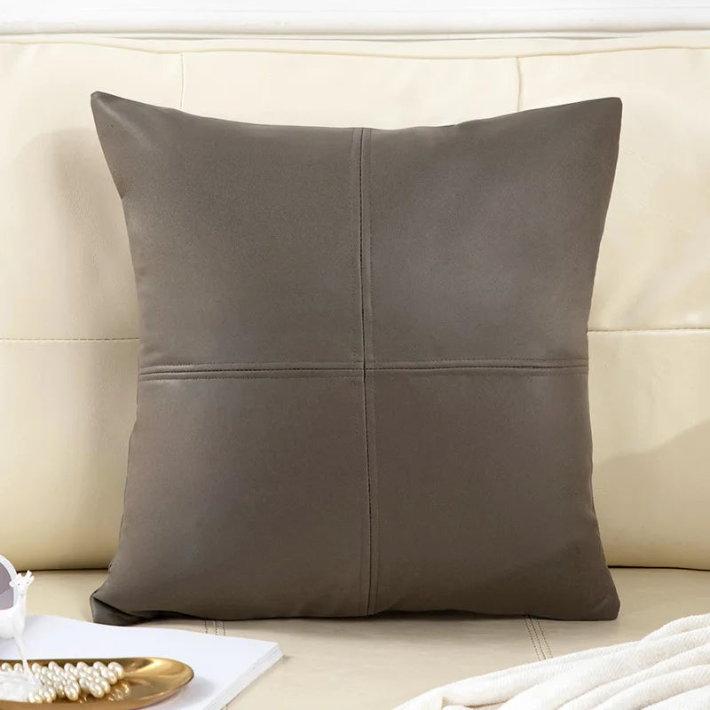 Gray leather pillow on a beige sofa