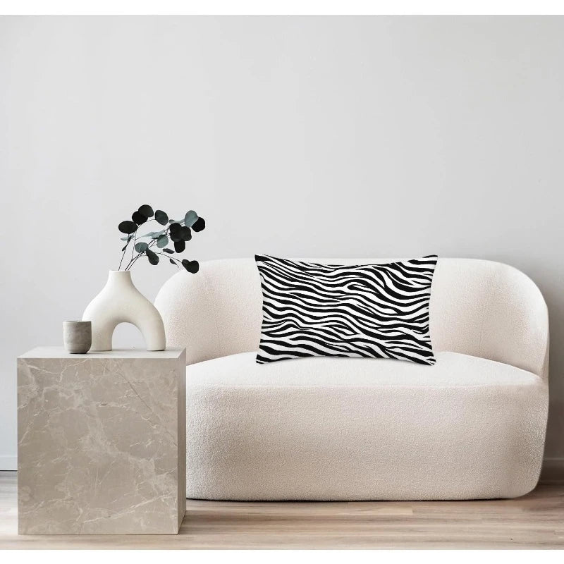 Modern living room with a white sofa, marble side table, and zebra-patterned pillow.