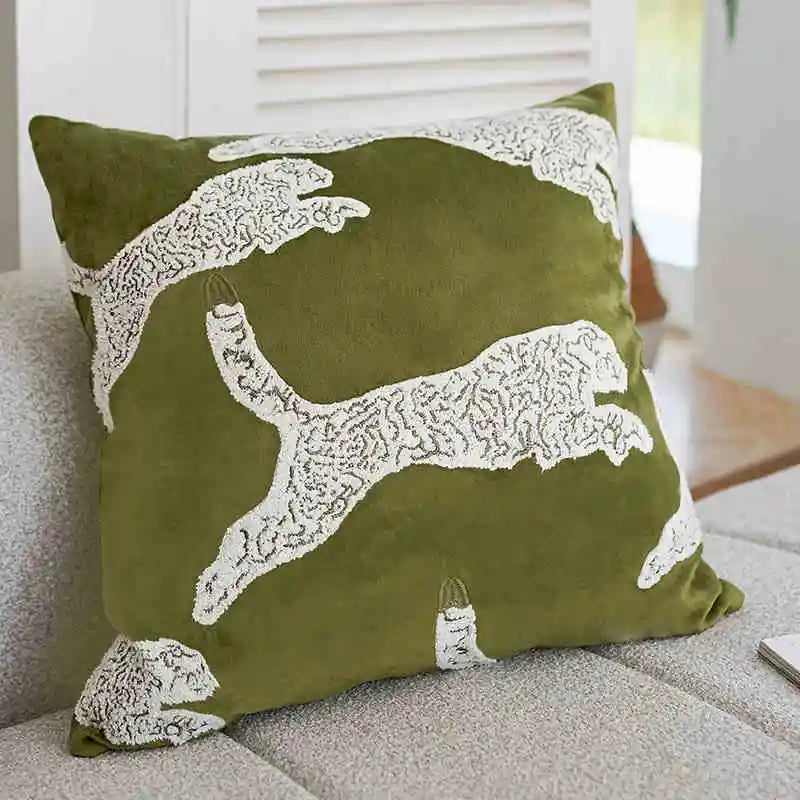 Green pillow with white animal design on a couch
