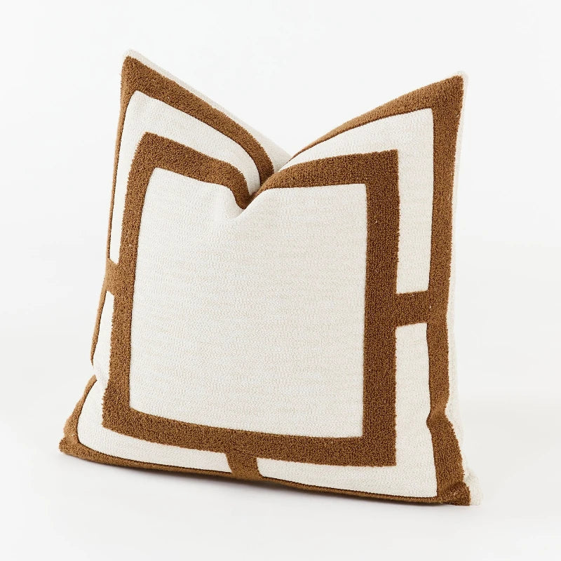 Decorative pillow with brown and white geometric pattern on a white background