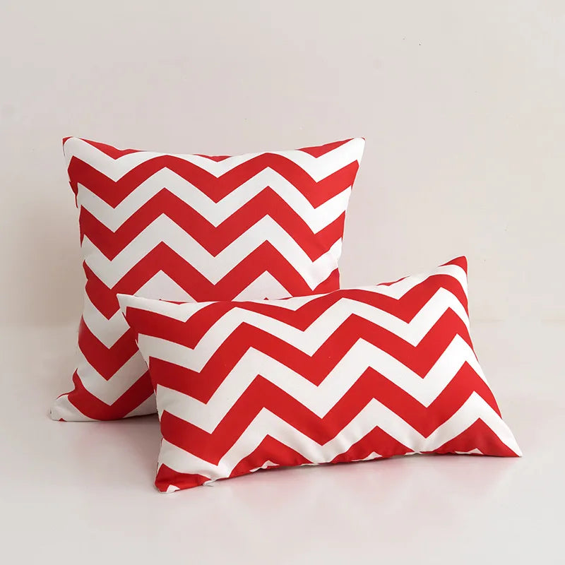 Two red and white chevron patterned pillows on a light background