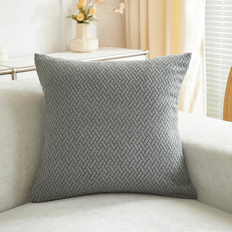 Gray textured pillow on a light-colored sofa with a blurred background