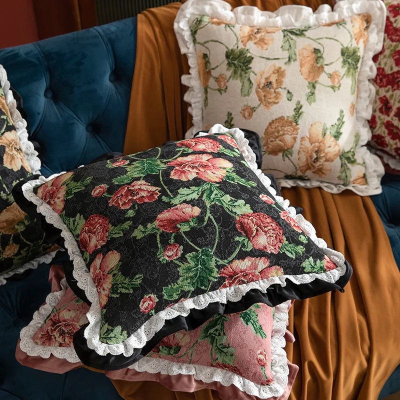 Floral patterned cushions with ruffled edges on a colorful sofa.
