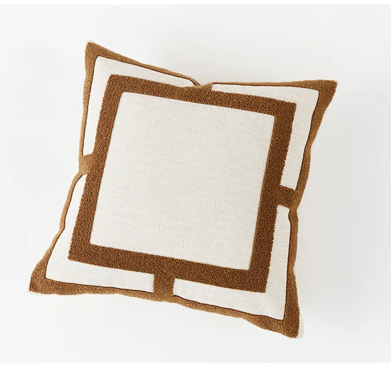 Two square pillows with brown and white geometric patterns on a white background