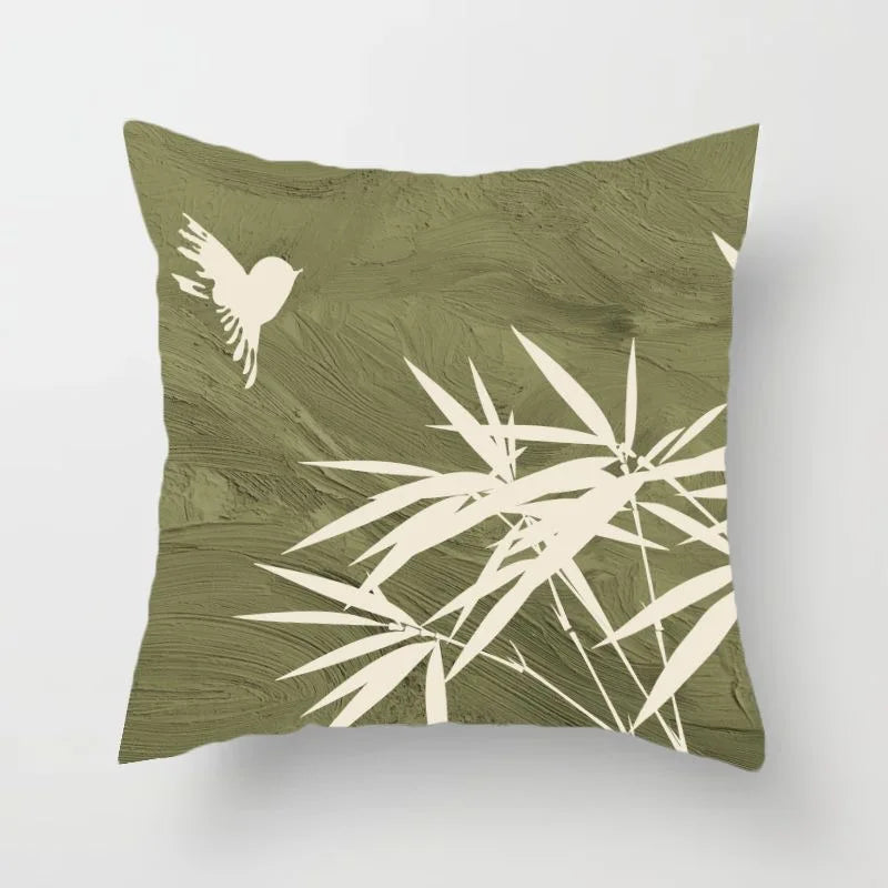 Green pillow with white leaf and bird design on a white background