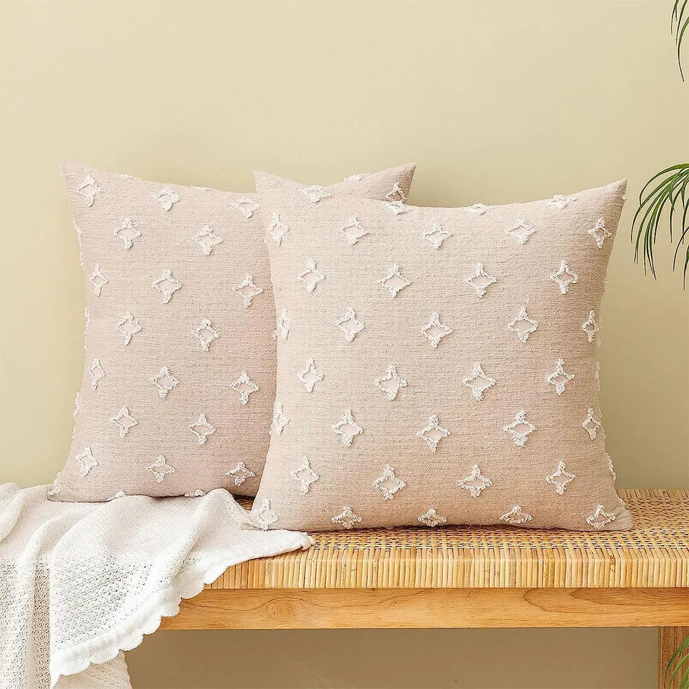 Two beige tufted pillows on wooden bench.