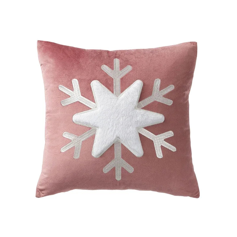 Pink pillow with a white snowflake design on a white background