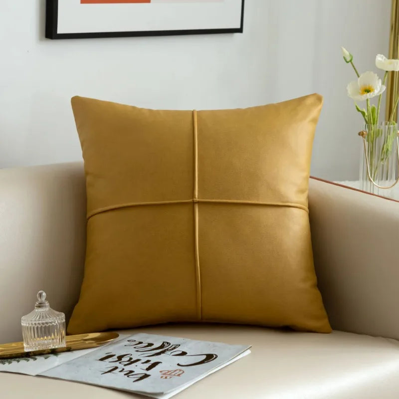 Mustard yellow pillow on a beige sofa with a magazine and decorative items in the background.